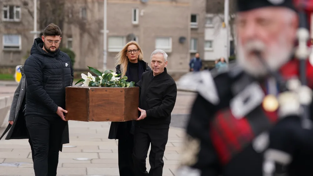 Campaigners holding a coffin take part in a demonstration outside the Scottish Parliament at Holyrood