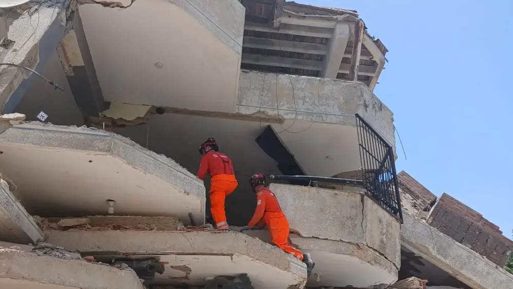 Rescue personnel attempt to enter a collapsed building in Venezuela