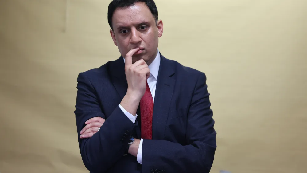 Anas Sarwar standing, with one hand on his face