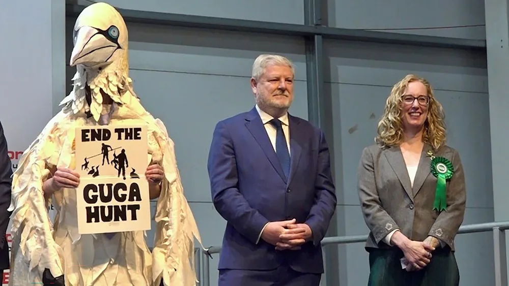 (From left) Wildlife campaigner and election candidate Robert Pownall, dressed as a gannet, Angus Robertson, and Lorna Slater listening to the constituency results being declared