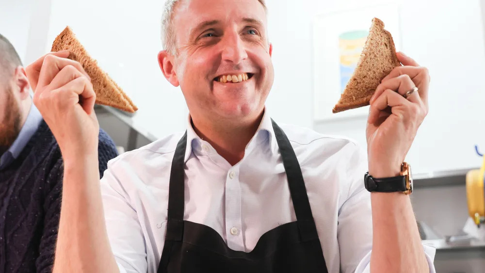 Alex Cole-Hamilton holds up two slices of bread during a visit to Glasgow City Mission