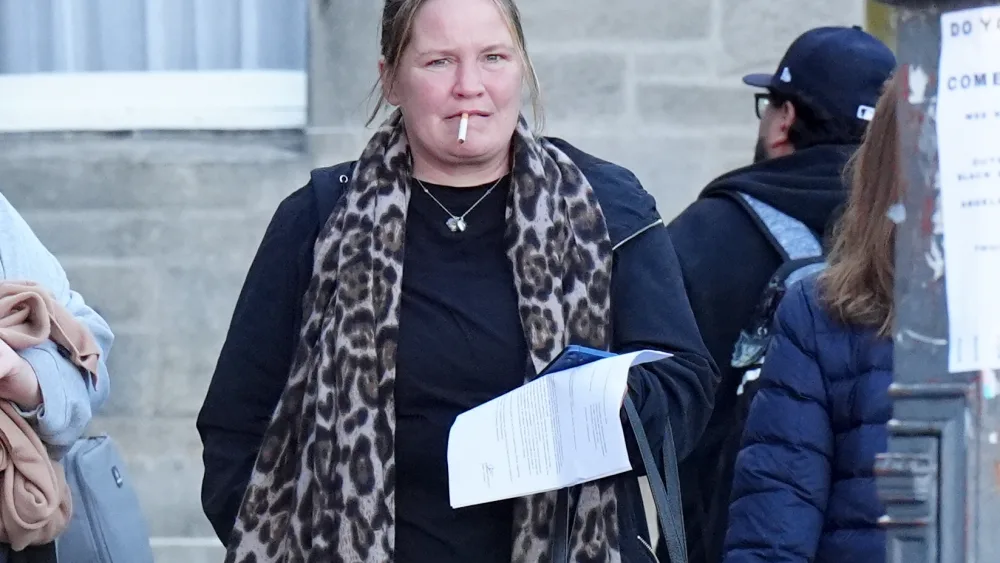 Simone Ramage walking outside, with a cigarette in her mouth