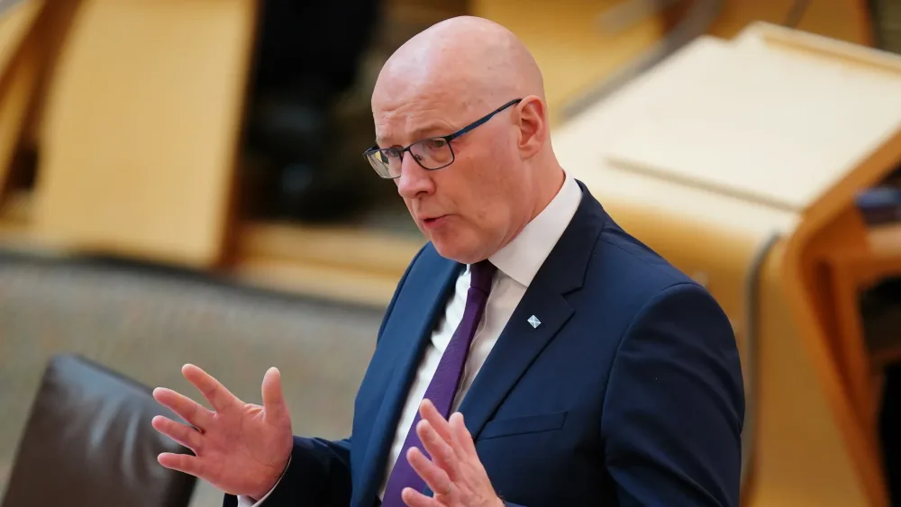 John Swinney gesturing with his hands during a speech