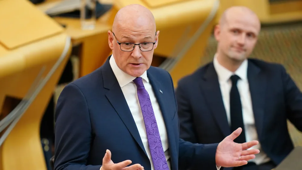 John Swinney gesturing with his hands during a speech