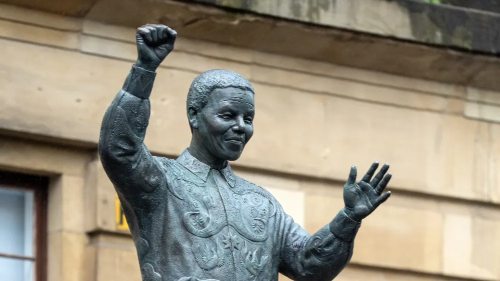 A statue of Nelson Mandela is unveiled by representatives from the Nelson Mandela Scottish Memorial Foundation, in Glasgow