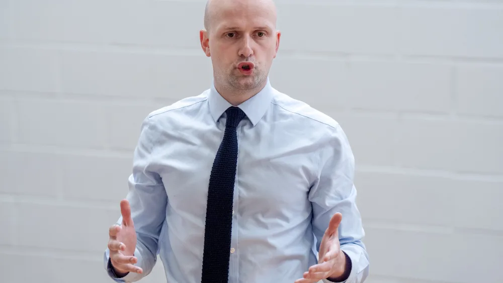 Stephen Flynn gesturing with both hands while speaking