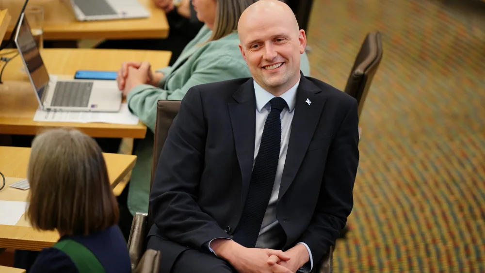 Stephen Flynn smiling while seated in the Holyrood chamber