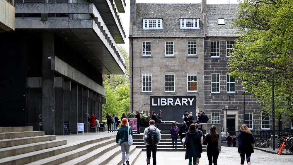 Students walking outside, with a building marked 'library' in the centre of the photo