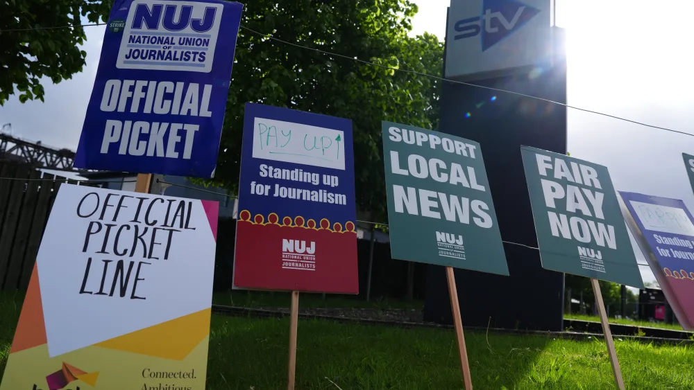 Placards on display at a picket line, with the STV sign behind it