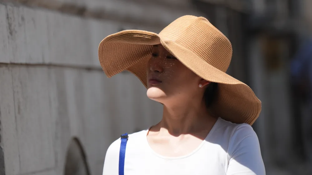 A woman wearing a large-rimmed sunhat