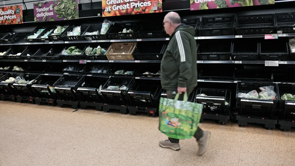 A man with a shopping basket in a supermarket