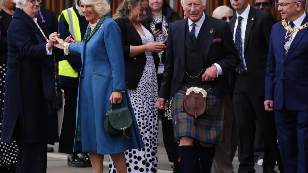 The King wearing a kilt and Queen meeting people outside the Scottish Parliament