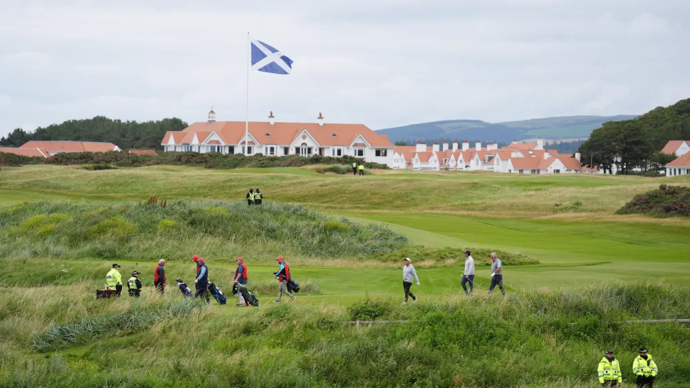 Police officers look on as golfers play at US President Donald Trump’s Turnberry golf course