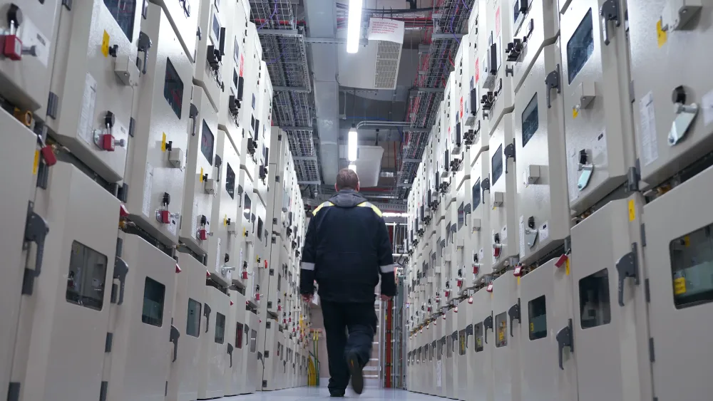 A man seen from behind walking inside data centre
