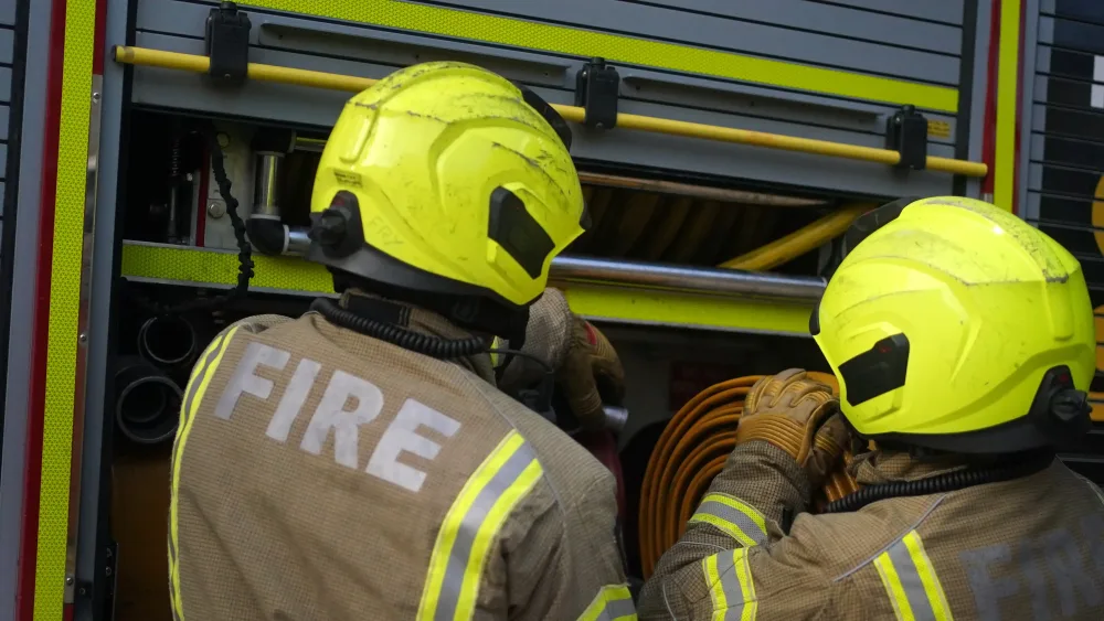 Two firefighters beside a fire engine