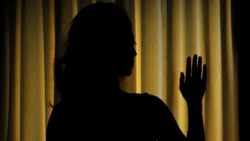 Silhouette of woman at window looking out